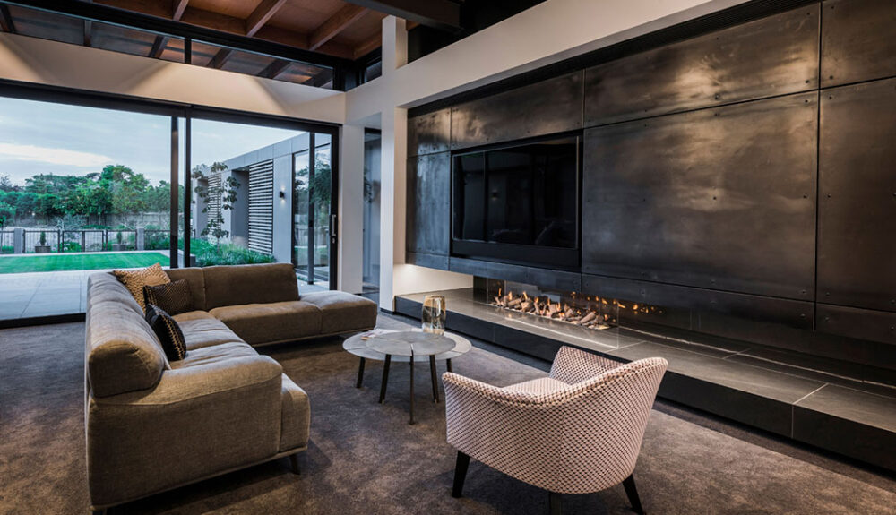 This modern home showcases a bespoke gas fireplace, the Eastside Euro, by Living Flame as a hero focal point to create a warm and cozy atmosphere in the living room.